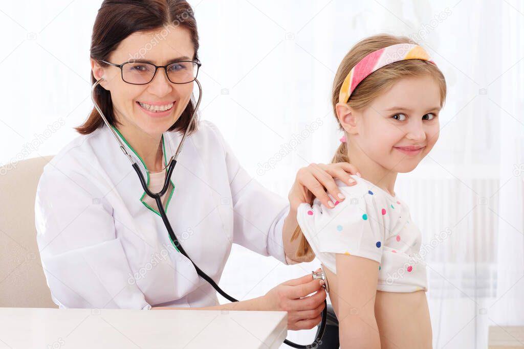 Doctor listening to girl with stethoscope