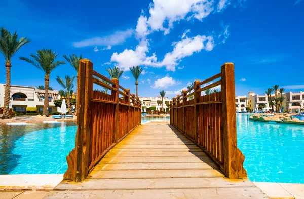 View on wooden bridge across hotel pool — Stock Photo, Image