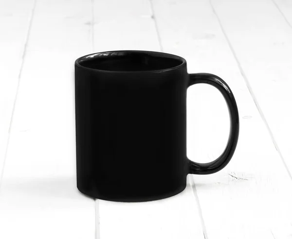 Fekete csésze egy fehér asztalon — Stock Fotó