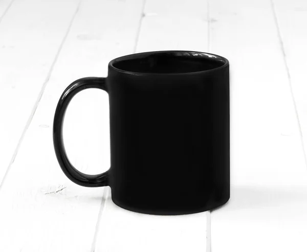 Taza negra sobre una mesa blanca —  Fotos de Stock