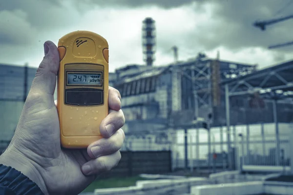 Radiometer in hand with fourth Chernobyl Nuclear Power Plant — Stock Photo, Image