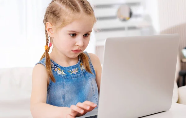 Liten flicka som använder sin bärbara dator — Stockfoto