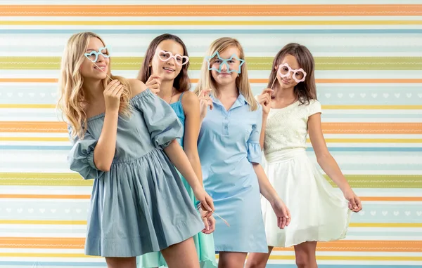 Pretty smiling teenage girls in dresses standing together a — Stock Photo, Image