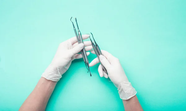 Mãos na luva segurando ferramentas dentárias — Fotografia de Stock