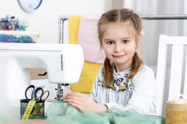 Küçük kız dikiş makinesinde el sanatları yapma