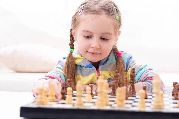 Söt liten flicka spelar schack — Stockfoto