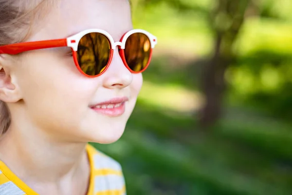 Malá usměvavá dívka v chladné sluneční brýle — Stock fotografie