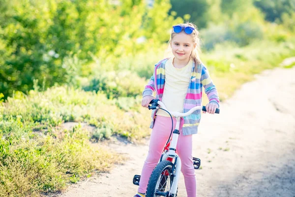 Bambina in piedi con bici — Foto Stock