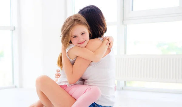 Mutter mit ihrer kleinen Tochter Mädchen umarmt — Stockfoto