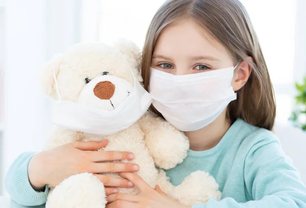 Meisje met pluche teddy dragen maskers — Stockfoto