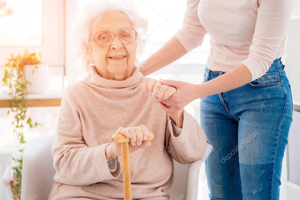 Grandmother supported by woman