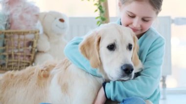 Gülümseyen küçük kız sevimli köpeğe sarılıyor.