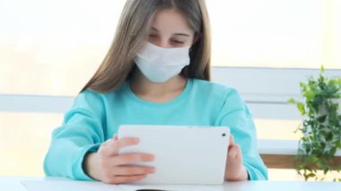 Tablet kullanan maskeli kız