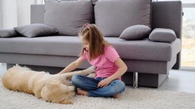 Küçük kız köpeği elleriyle besliyor.