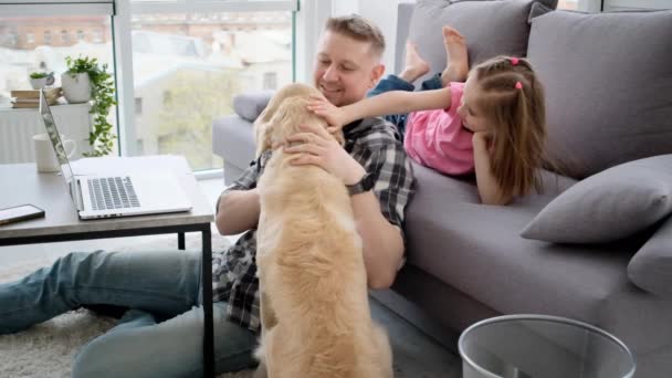 Улыбающаяся девушка с отцом, ласкающим собаку — стоковое видео