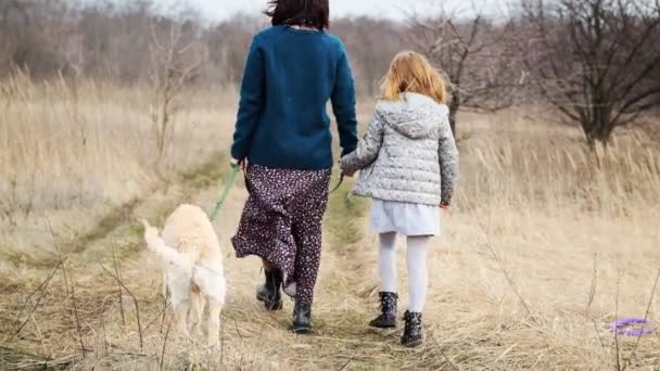 Chica y mujer paseando perro — Vídeo de stock