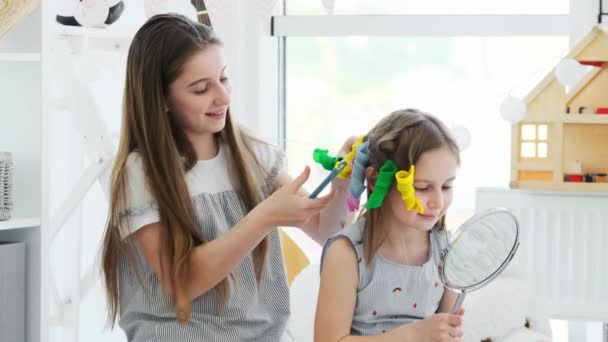 Chicas guapas haciendo rizos con rodillos — Vídeo de stock