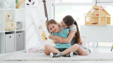Güzel gülümseyen kız kardeşler mutlu bir şekilde sarılıyorlar