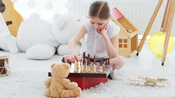 Pretty little girl playing chess — Stock Video