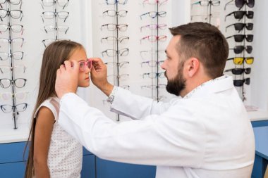 Kız ve doktor gözlük seçiyor.