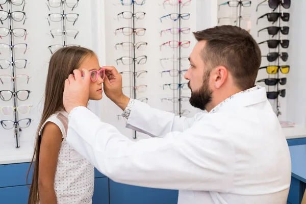 Chica y médico elegir gafas — Foto de Stock