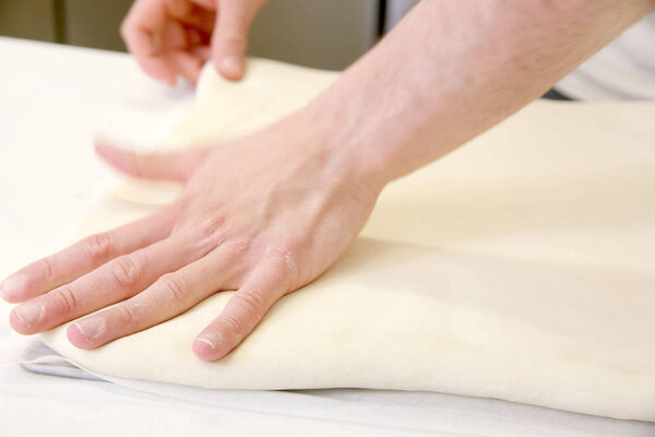 Making dough by male hands at bakery closeup