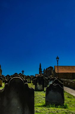 Koyu mavi arka plana karşı mezar taşları. Taşlara yazıtlar eklemek için en üste ve odaya boşluk kopyala.
