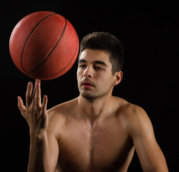 Geïsoleerde beeld van een basketbal-speler een bal op vinger spinnen — Stockfoto