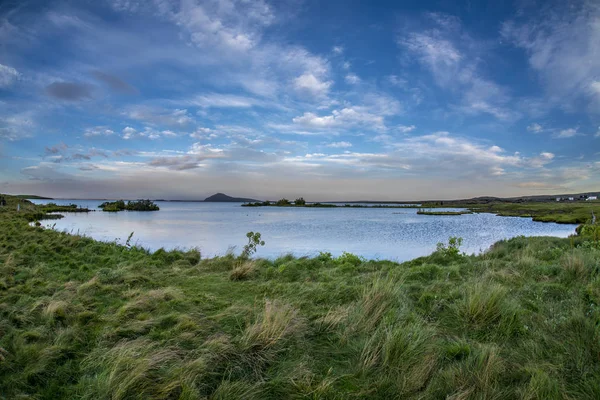 Corpo de água do lago ao lado de um corpo de terra de grama — Fotografia de Stock