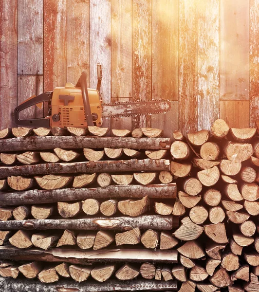 Bois de chauffage empilé avec tronçonneuse vintage — Photo