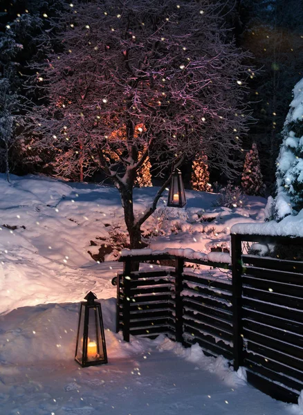 Lanterns in Christmas snowfall garden — Stock Photo, Image