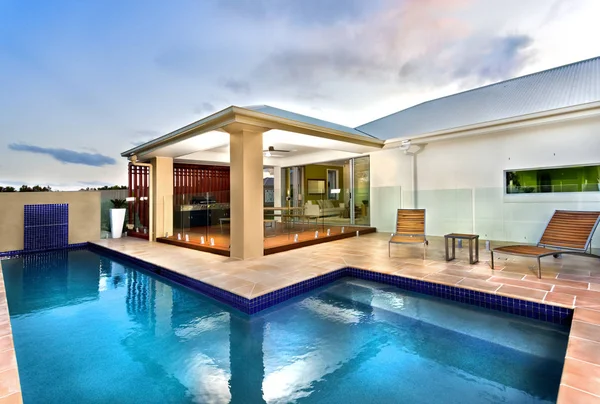 Hôtel de luxe avec piscine d'eau bleue dans un ciel sombre — Photo