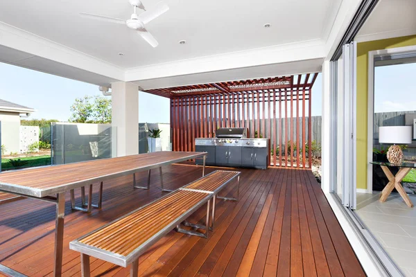 Long wooden table and benches with modern grill cabinet  in a lu — Stock Photo, Image