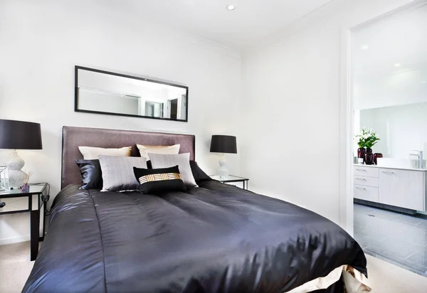 Nowoczesne łóżko z bliska z czarnym materac obok łazienki — Zdjęcie stockowe