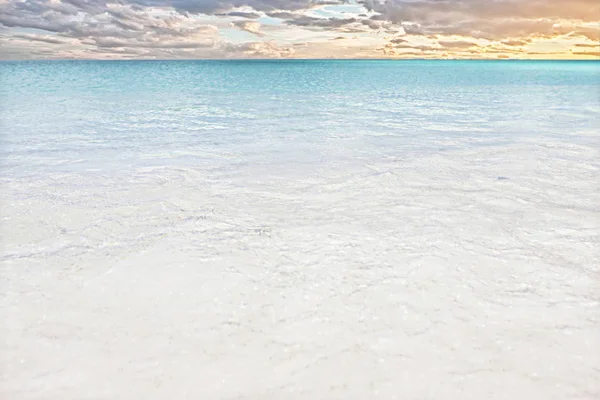 Aguas de la costa del mar en el horizonte de arena y nubes — Foto de Stock