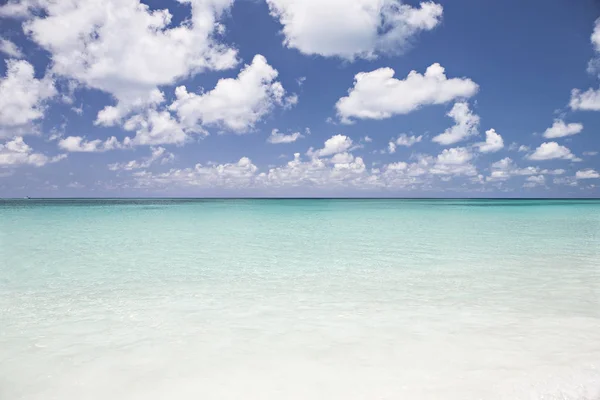 Mar de agua azul claro y cielo azul con nubes — Foto de Stock