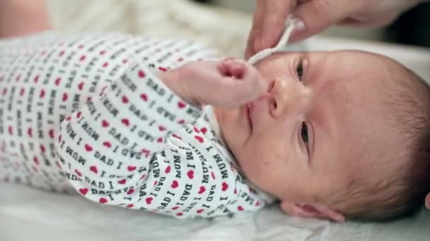 Mutter reinigt Gesicht von neugeborener Babyhand — Stockvideo