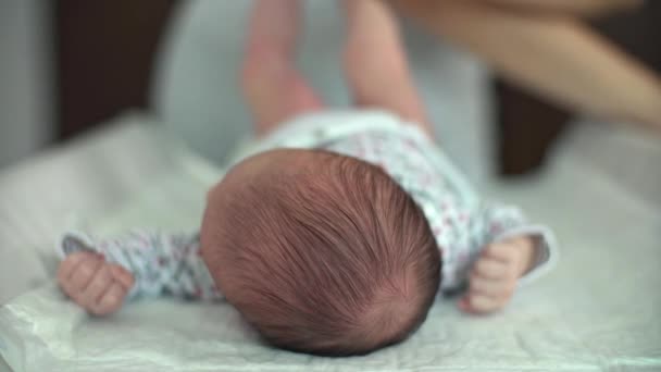 Madre cambiando el bebé del pañal en la mesa de cambio — Vídeo de stock