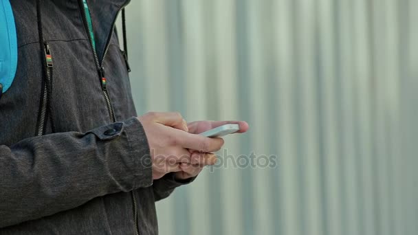 Tipo de manos masculinas en el teléfono al aire libre en el día frío — Vídeos de Stock