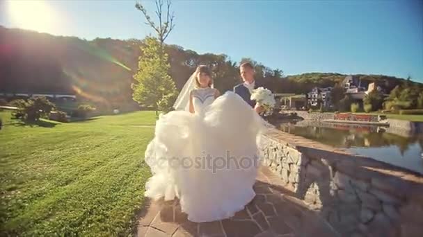 Svatební pár jít do kamery přírodní venkovní poblíž jezera — Stock video