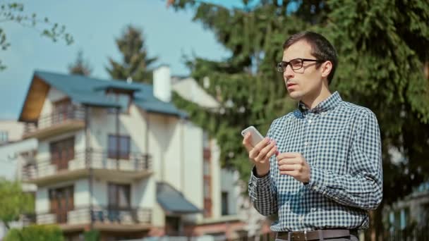 Jonge man bedrijf mobiele telefoon — Stockvideo