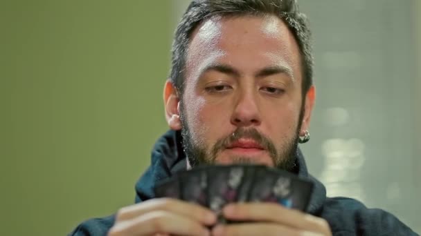 Νεαρός άνδρας κρατά το επιτραπέζιο παιχνίδι καρτών — Αρχείο Βίντεο