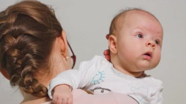 Anne bebek omzunda tutar.