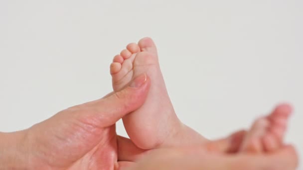 Madre masajeando pequeños pies de bebé — Vídeo de stock