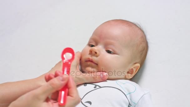 Малышка принимает лекарство ложкой — стоковое видео