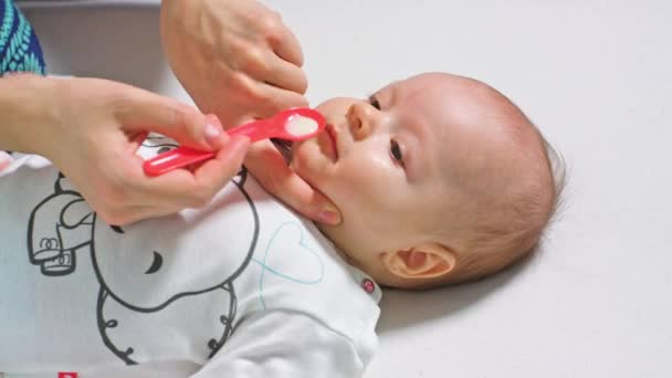 Meisje van de baby is nemen geneesmiddel door een lepel — Stockvideo