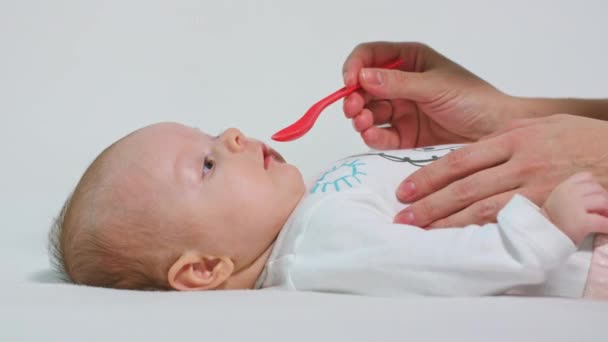 Bebé niña está tomando medicina por una cuchara — Vídeos de Stock