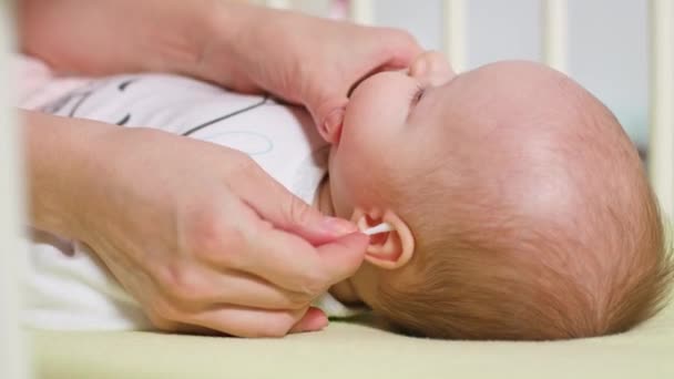 Moeder is het reinigen van de oren van haar baby — Stockvideo