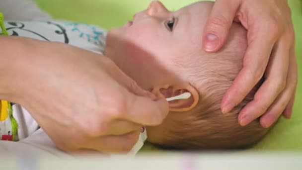 Madre está limpiando sus orejas de bebé — Vídeos de Stock