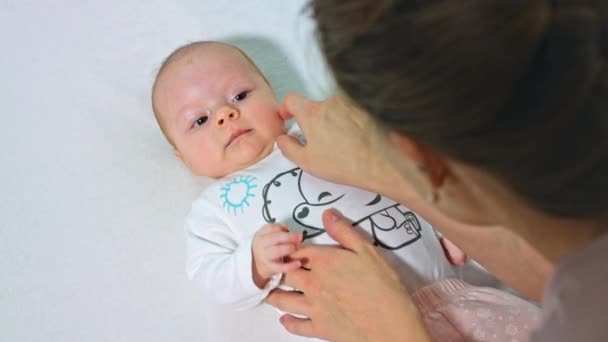 Мать чистит ребенку нос — стоковое видео